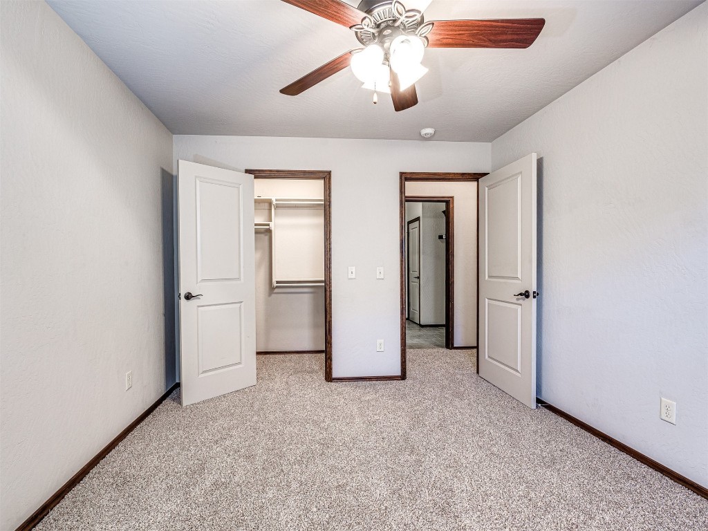 13512 Borgata Lane, Oklahoma City, OK 73170 unfurnished bedroom with a closet, ceiling fan, a spacious closet, and light carpet