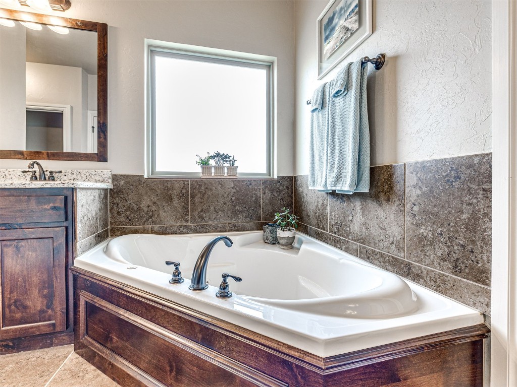12600 SW 24th Street, Yukon, OK 73099 bathroom featuring a washtub, vanity, and tile floors