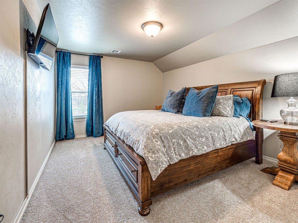 12600 SW 24th Street, Yukon, OK 73099 bedroom with light colored carpet and lofted ceiling