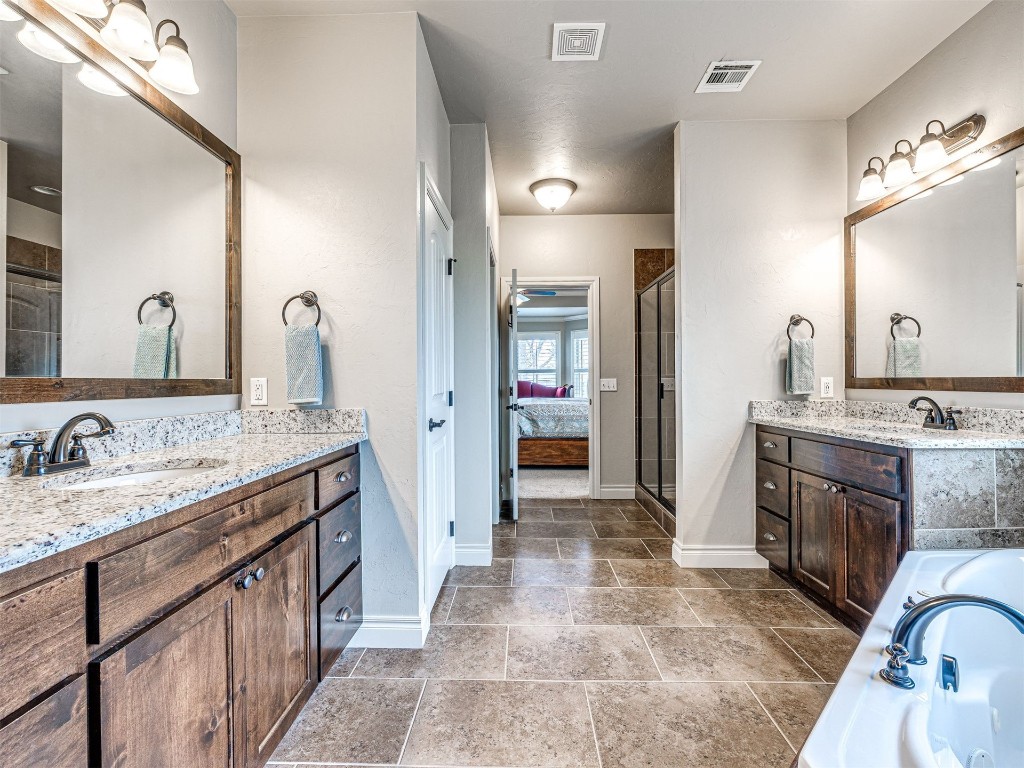 12600 SW 24th Street, Yukon, OK 73099 bathroom featuring tile floors, dual bowl vanity, and plus walk in shower