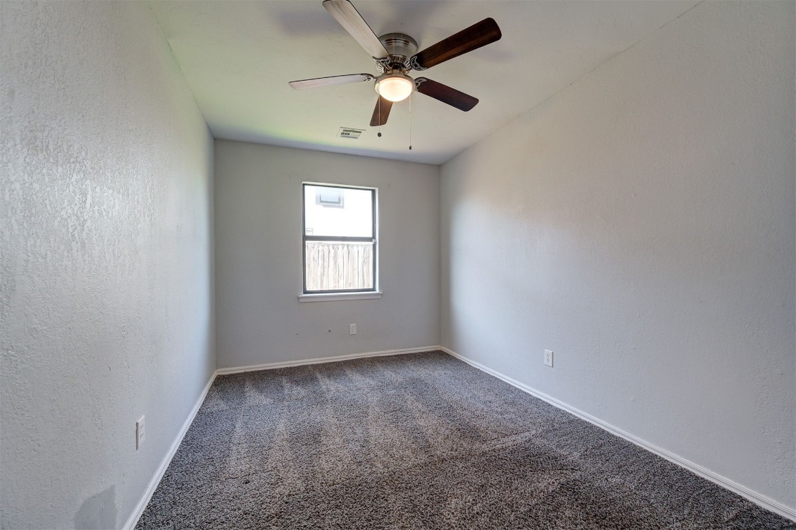 10101 Southridge Drive, Oklahoma City, OK 73159 spare room with dark colored carpet and ceiling fan