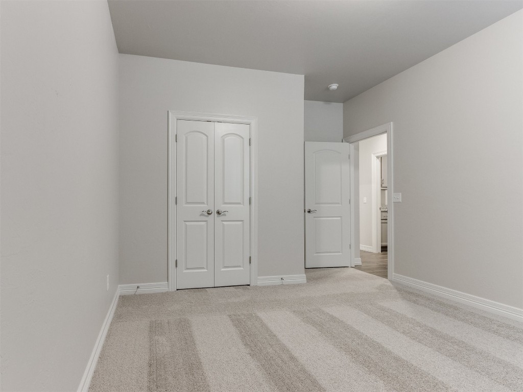 16200 Brenton Hills Avenue, Edmond, OK 73013 unfurnished bedroom featuring light carpet and a closet
