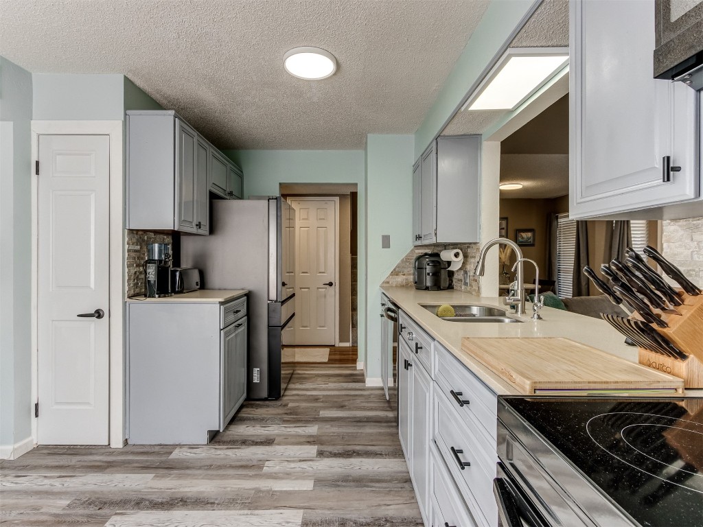 10511 Jeri Place, Oklahoma City, OK 73162 kitchen with backsplash, sink, and light hardwood / wood-style floors
