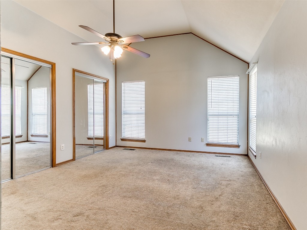 1013 SW 126th Street, Oklahoma City, OK 73170 carpeted empty room with a healthy amount of sunlight, high vaulted ceiling, and ceiling fan