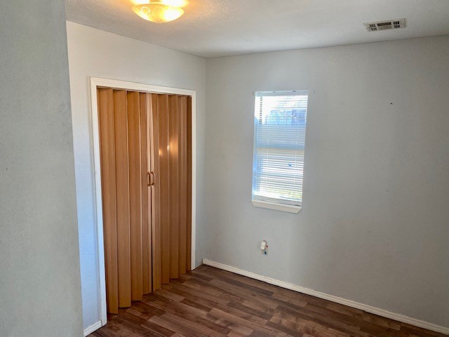 833 S Ellison Avenue, El Reno, OK 73036 unfurnished bedroom with a closet and dark wood-type flooring