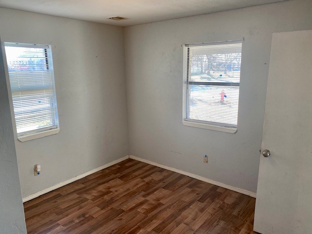 833 S Ellison Avenue, El Reno, OK 73036 unfurnished room with plenty of natural light and dark hardwood / wood-style floors