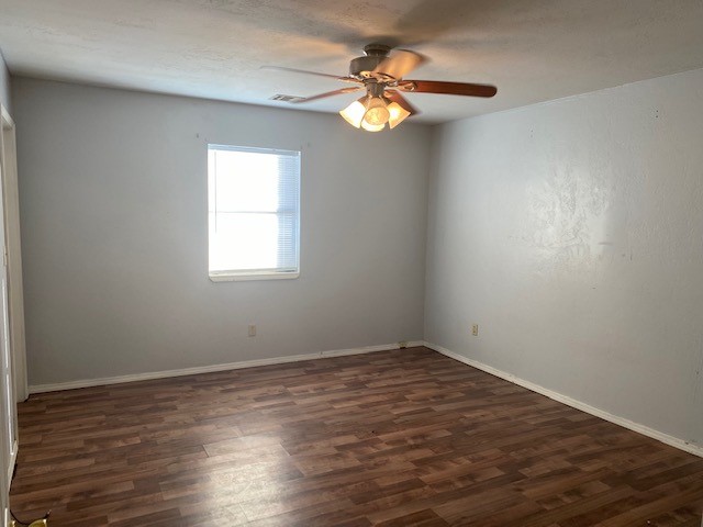 833 S Ellison Avenue, El Reno, OK 73036 unfurnished room featuring dark hardwood / wood-style flooring and ceiling fan