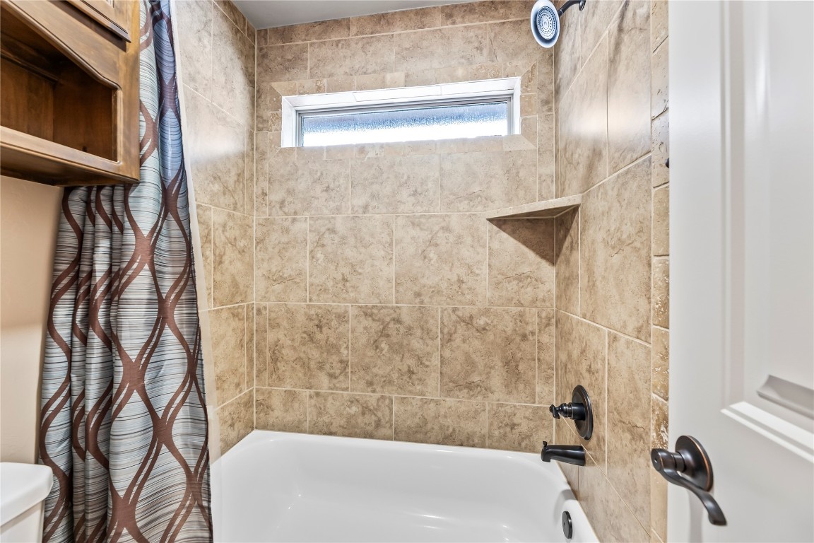11200 SW 41st Terrace, Mustang, OK 73064 bathroom featuring toilet and tiled shower / bath combo