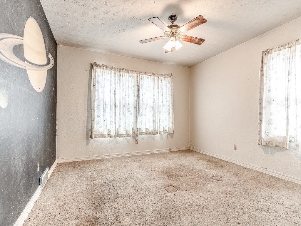 4805 N Hamilton Drive, Oklahoma City, OK 73112 carpeted empty room featuring ceiling fan, a textured ceiling, and a wealth of natural light