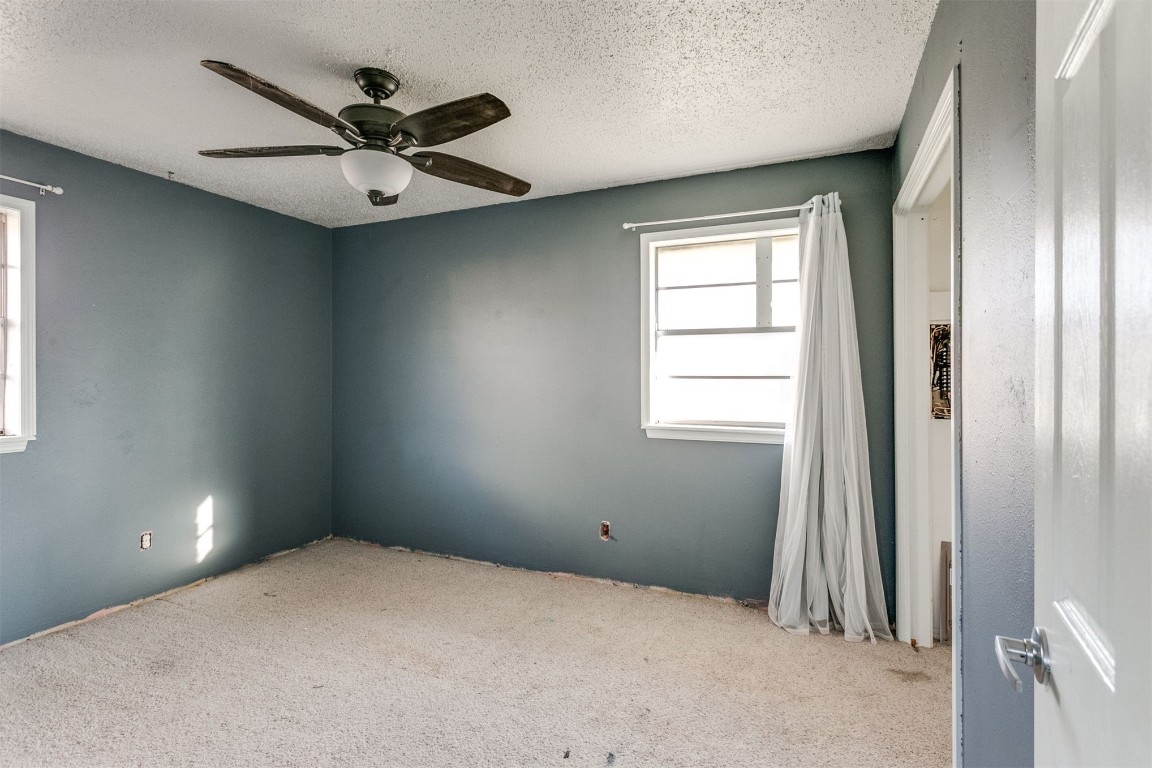5504 NW 67th Street, Warr Acres, OK 73132 spare room with a textured ceiling, light colored carpet, and ceiling fan