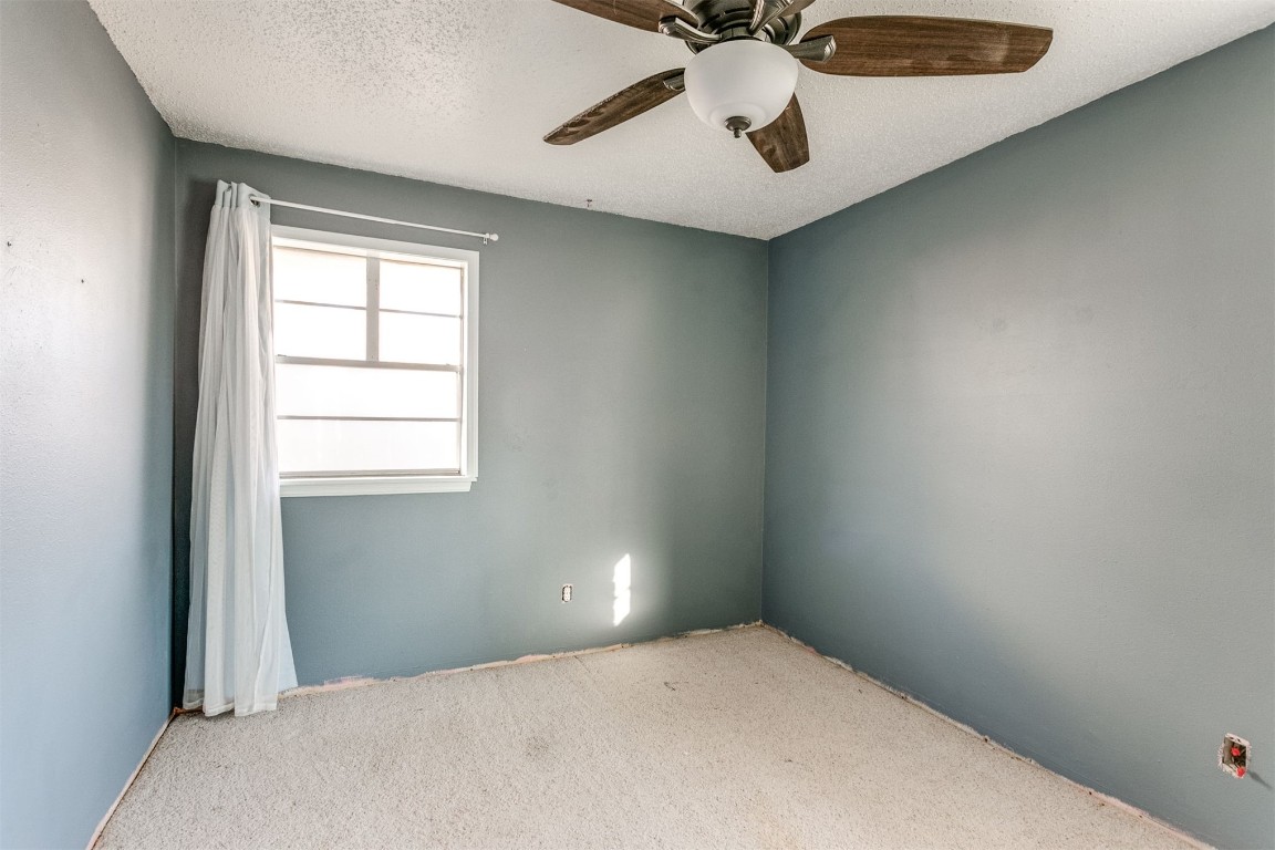 5504 NW 67th Street, Warr Acres, OK 73132 spare room featuring carpet flooring, a textured ceiling, and ceiling fan