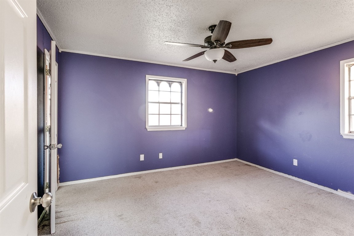 5504 NW 67th Street, Warr Acres, OK 73132 unfurnished room with light carpet, a textured ceiling, and ceiling fan