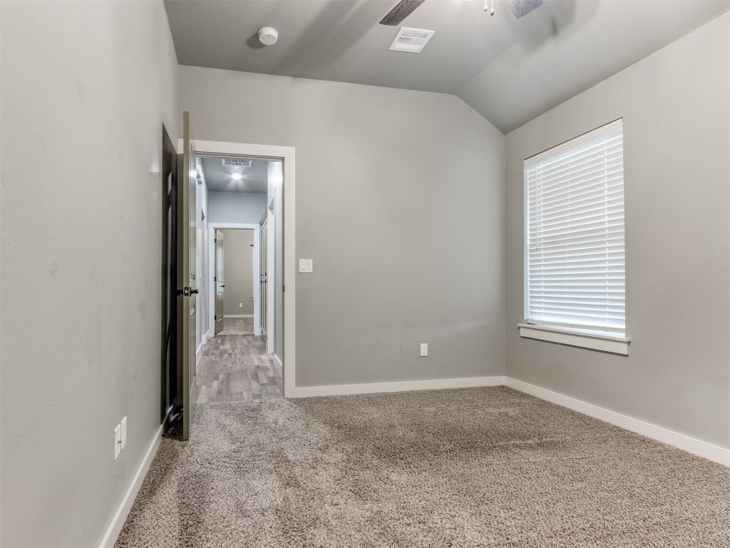 4832 Bermuda Drive, Mustang, OK 73064 carpeted empty room with ceiling fan and vaulted ceiling