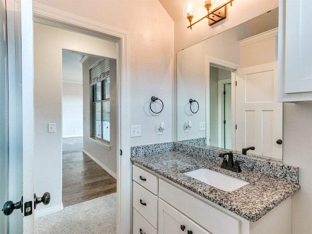 9328 SW 44th Terrace, Oklahoma City, OK 73179 bathroom featuring hardwood / wood-style flooring, ornamental molding, and large vanity