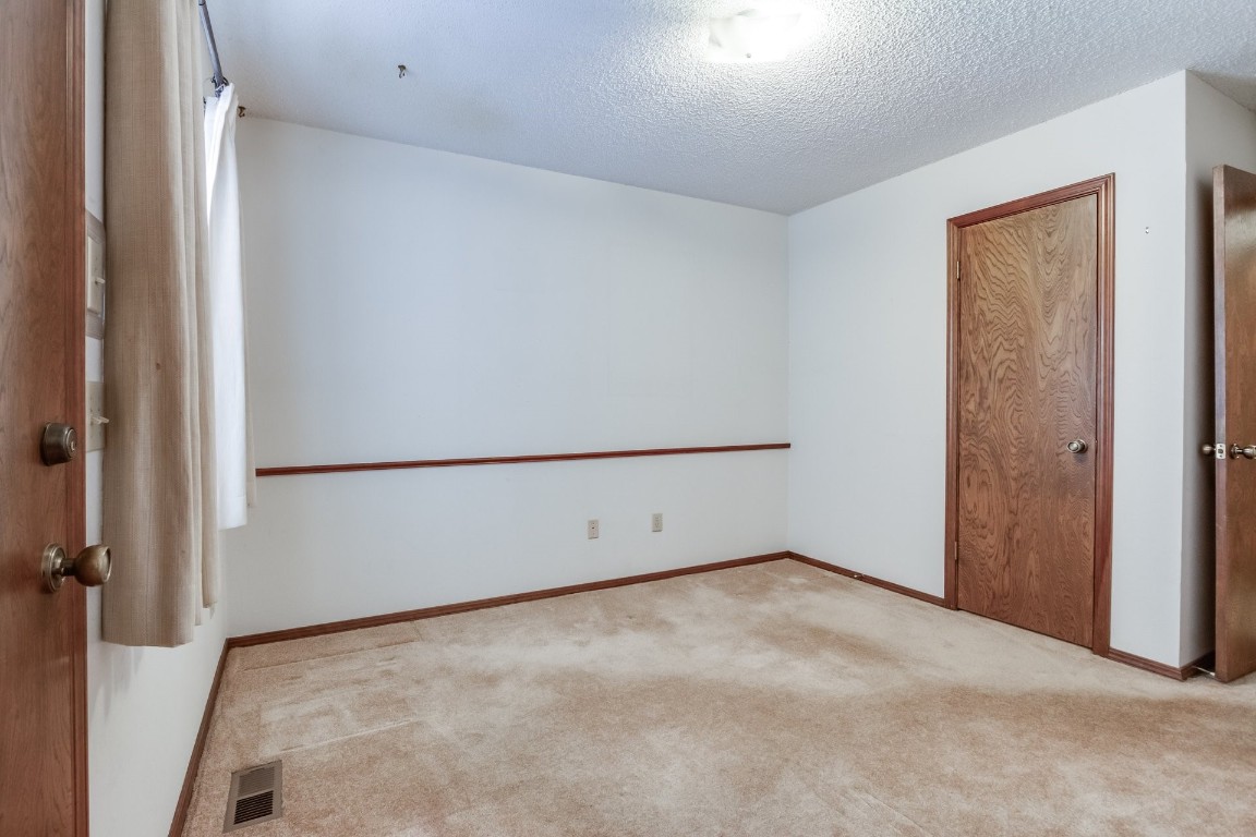 7201 Warriner Way, Oklahoma City, OK 73162 spare room with a textured ceiling and light colored carpet