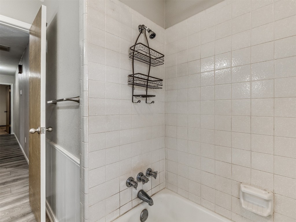 11313 Bluff Creek Drive, Oklahoma City, OK 73162 bathroom featuring tiled shower / bath combo and hardwood / wood-style flooring
