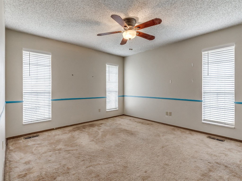 11313 Bluff Creek Drive, Oklahoma City, OK 73162 carpeted spare room featuring a textured ceiling and ceiling fan