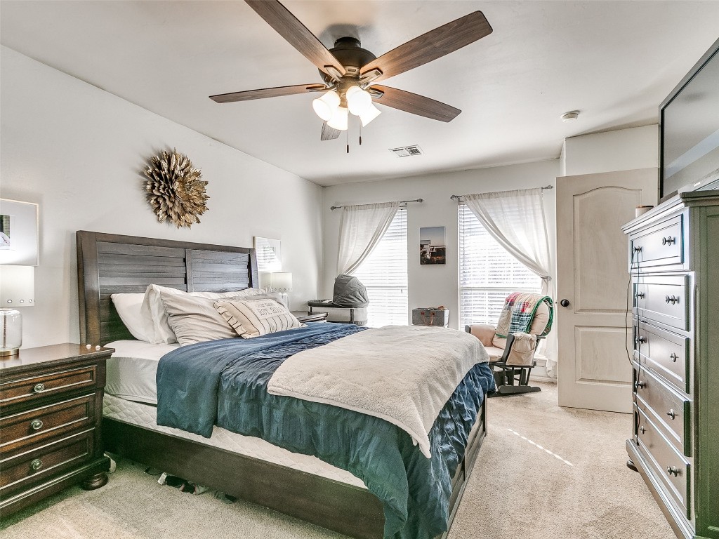 4605 Elk Creek Drive, Yukon, OK 73099 bedroom featuring ceiling fan and light colored carpet
