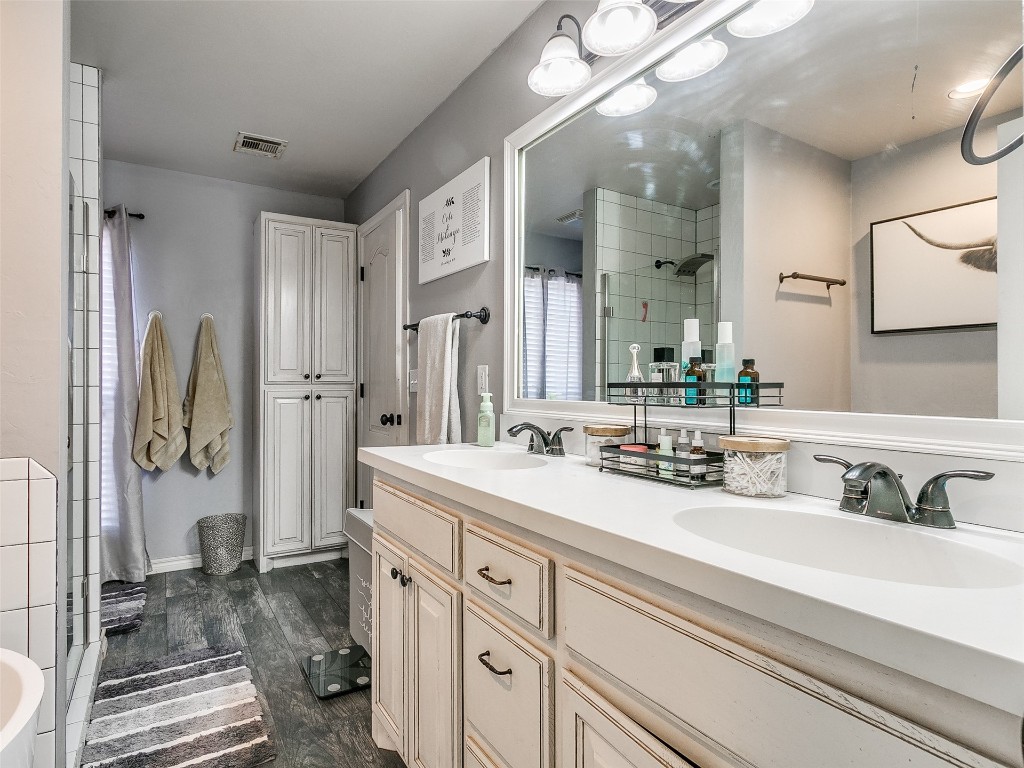 4605 Elk Creek Drive, Yukon, OK 73099 bathroom with vanity with extensive cabinet space, double sink, and hardwood / wood-style floors