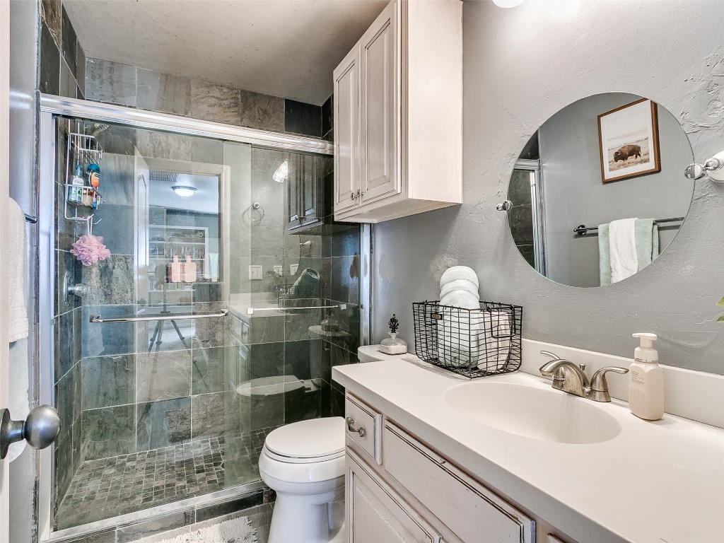 4605 Elk Creek Drive, Yukon, OK 73099 bathroom featuring a shower with door, large vanity, and toilet