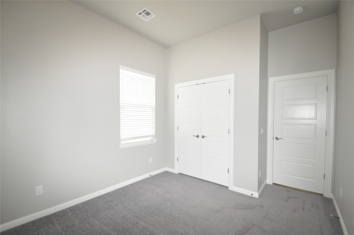 12901 SW 26th Street, Yukon, OK 73099 unfurnished bedroom featuring a closet and dark carpet