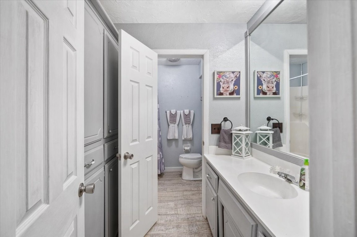 1915 Lankestar Way, Yukon, OK 73099 bathroom with hardwood / wood-style flooring, toilet, a textured ceiling, and vanity