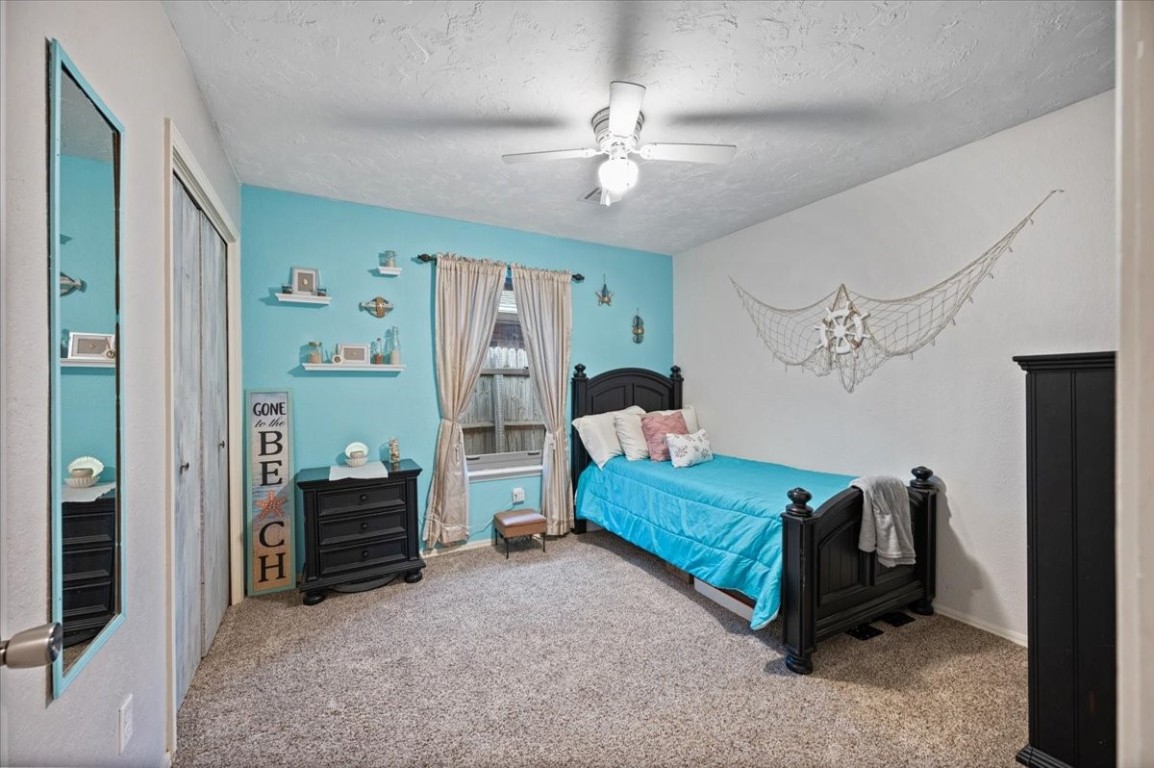 1915 Lankestar Way, Yukon, OK 73099 bedroom with a closet, a textured ceiling, carpet, and ceiling fan