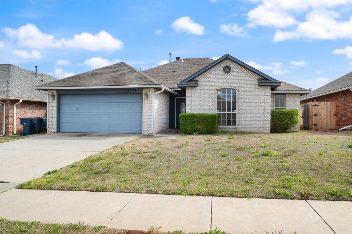12512 SW 13th Street, Yukon, OK 73099 single story home featuring a front yard and a garage
