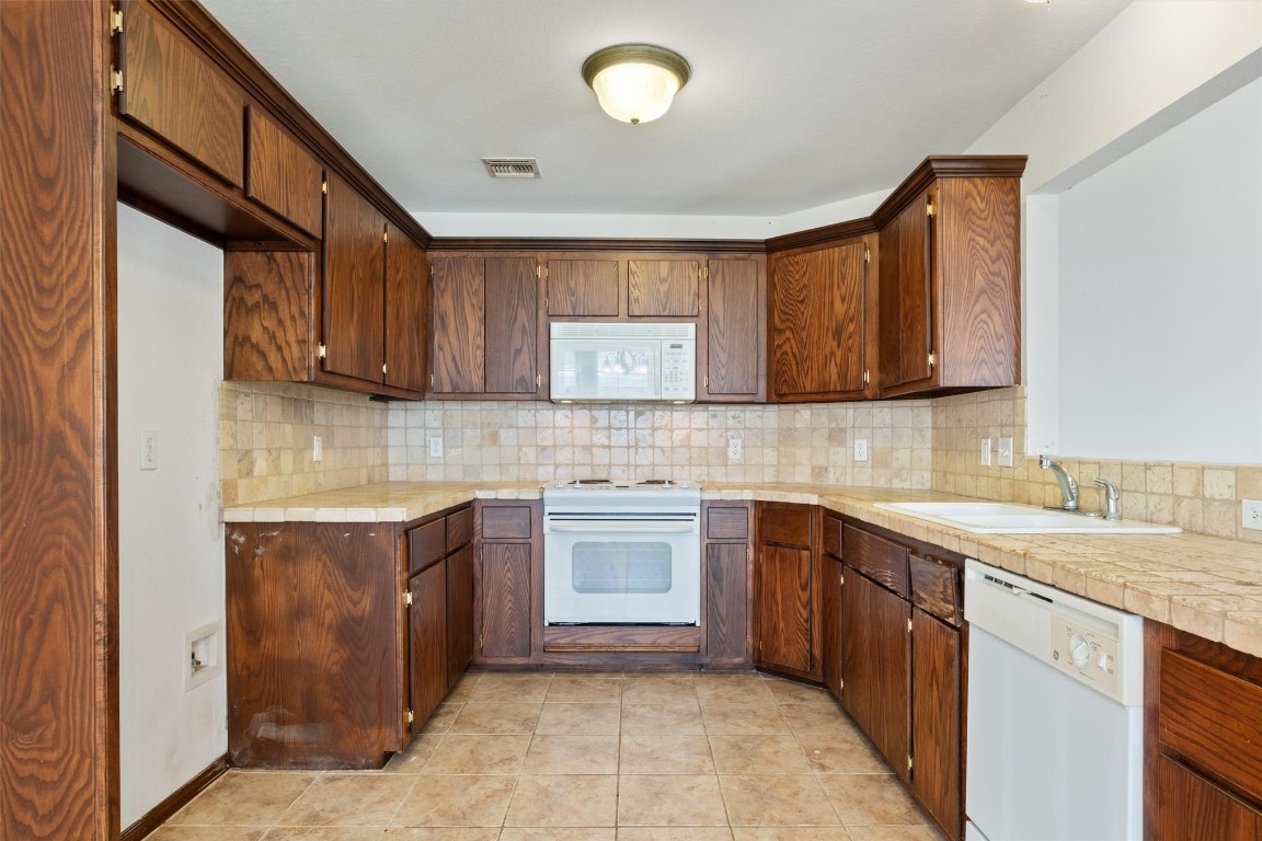 12512 SW 13th Street, Yukon, OK 73099 kitchen with backsplash, white appliances, sink, and light tile floors