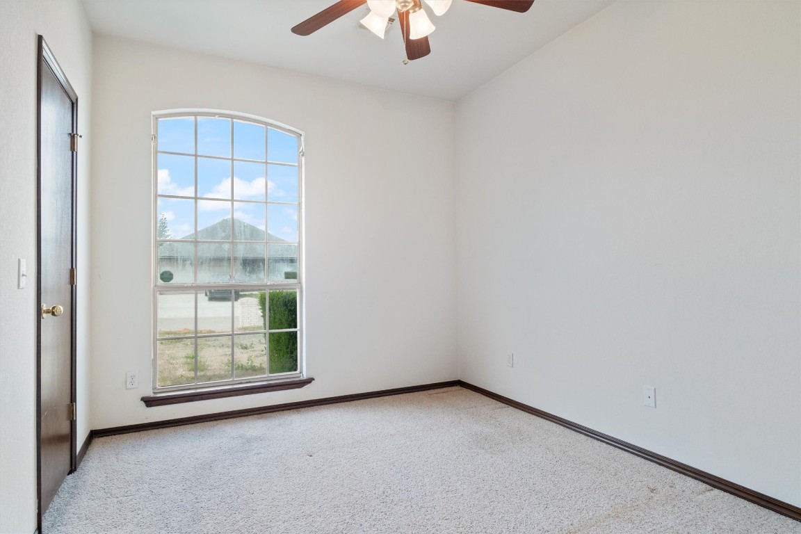 12512 SW 13th Street, Yukon, OK 73099 empty room with light colored carpet and ceiling fan