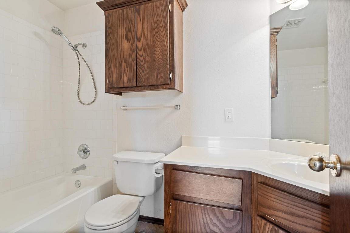 12512 SW 13th Street, Yukon, OK 73099 full bathroom with tiled shower / bath combo, vanity, and toilet