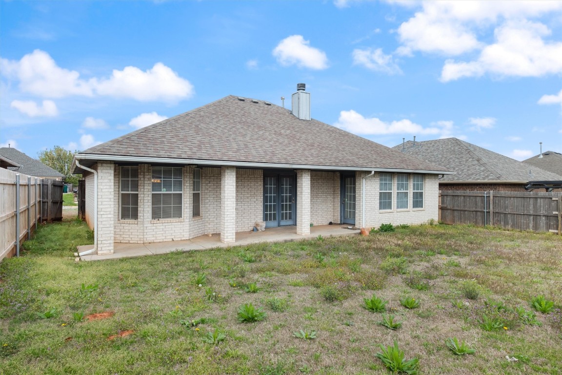 12512 SW 13th Street, Yukon, OK 73099 back of property with a lawn and a patio area