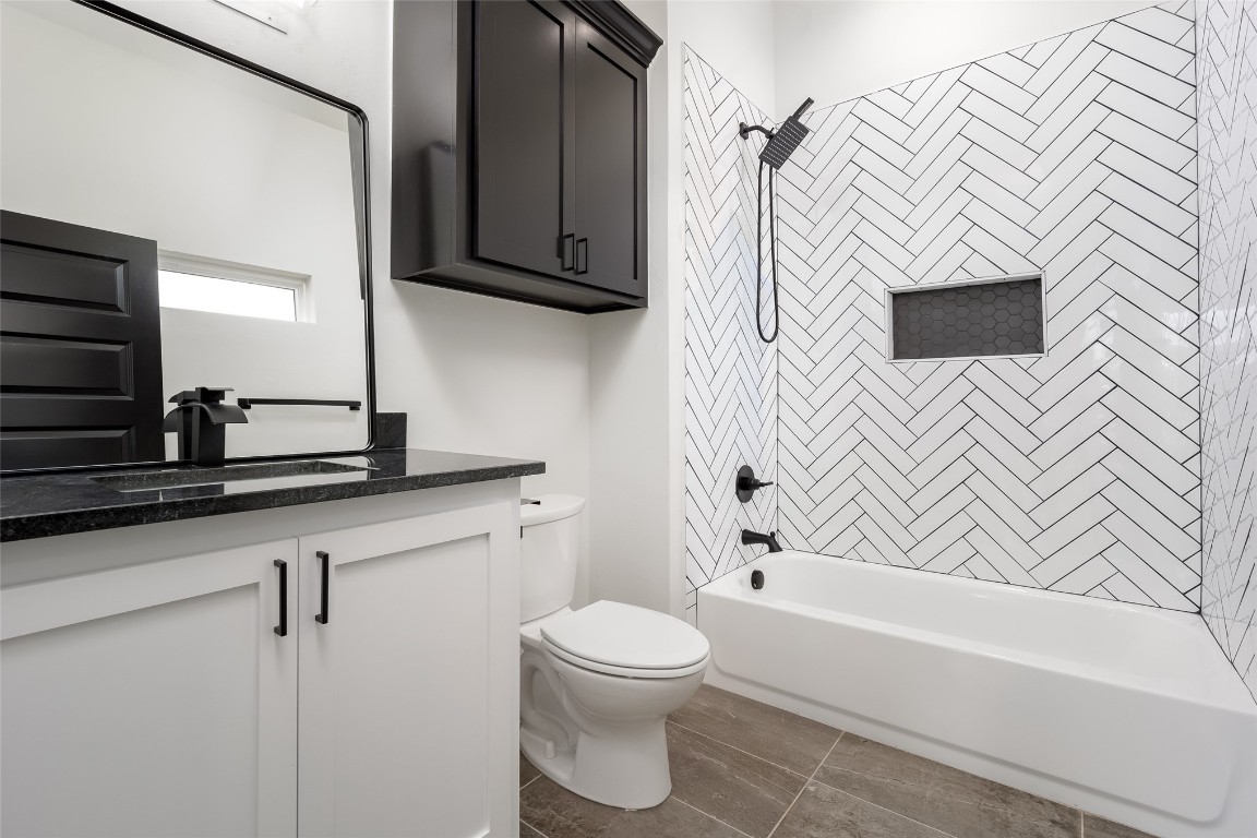 1383 S Gabes Court, Mustang, OK 73064 full bathroom featuring large vanity, toilet, tiled shower / bath, and tile flooring