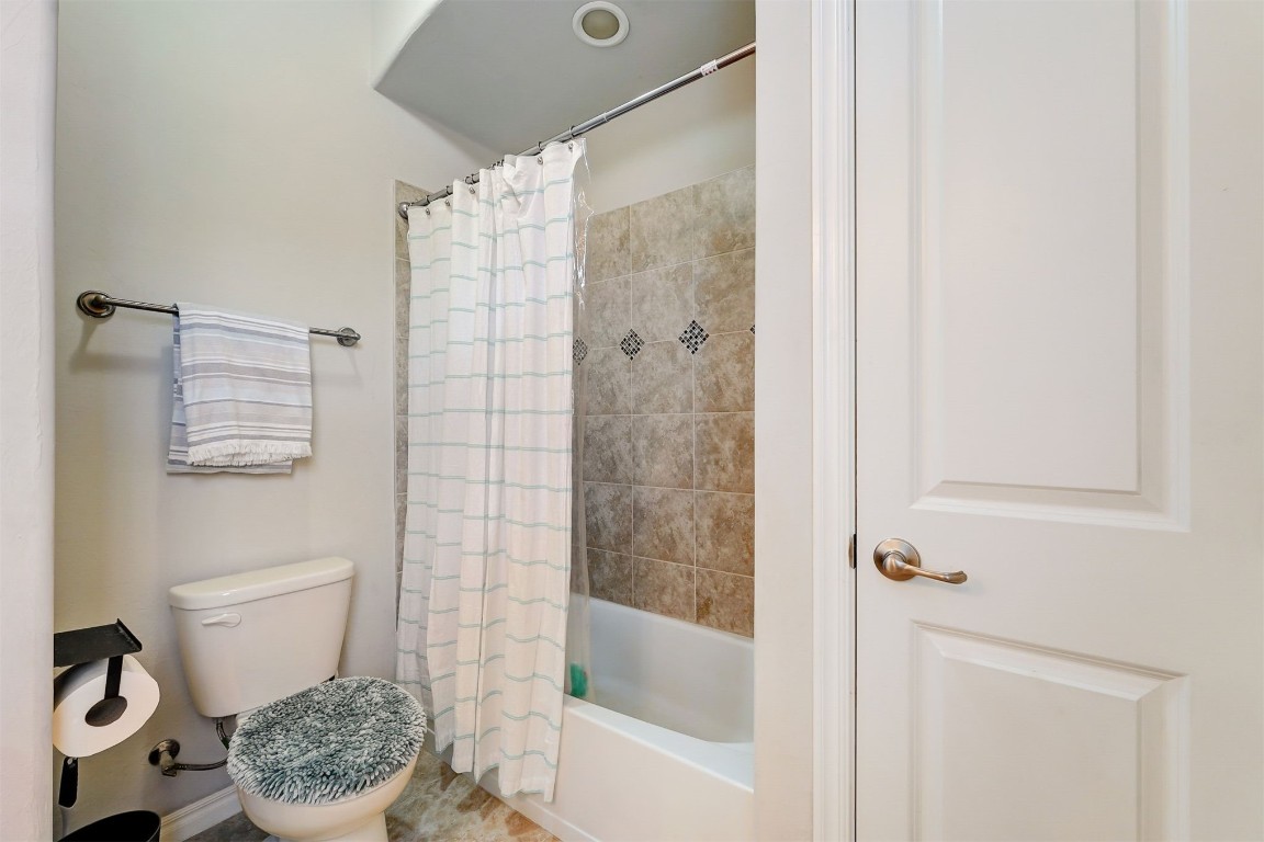 3508 Molly Drive, Yukon, OK 73099 bathroom with toilet and shower / bathtub combination with curtain