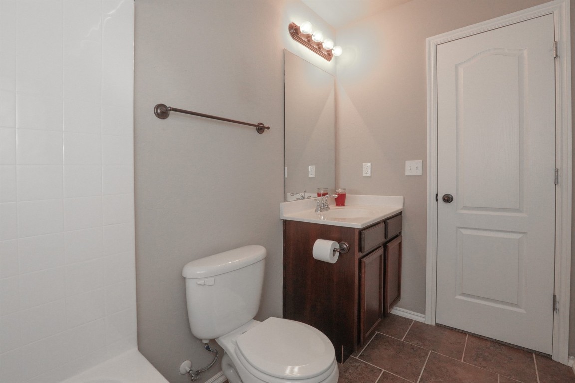 8417 SW 48th Street, Oklahoma City, OK 73179 bathroom featuring tile floors, oversized vanity, and toilet