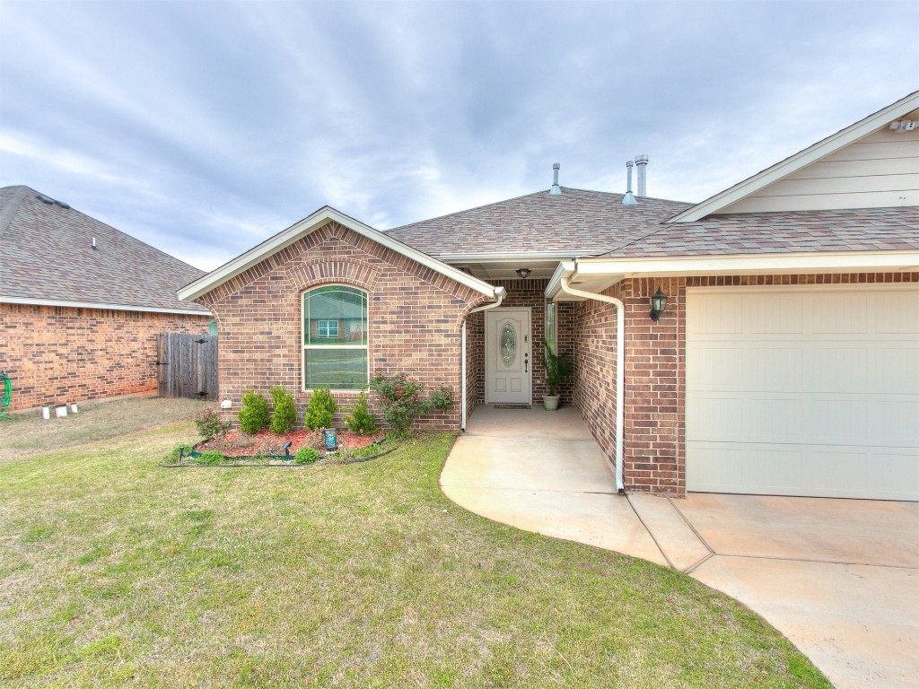 215 Tuscany Circle, Noble, OK 73068 ranch-style house featuring a front lawn and a garage