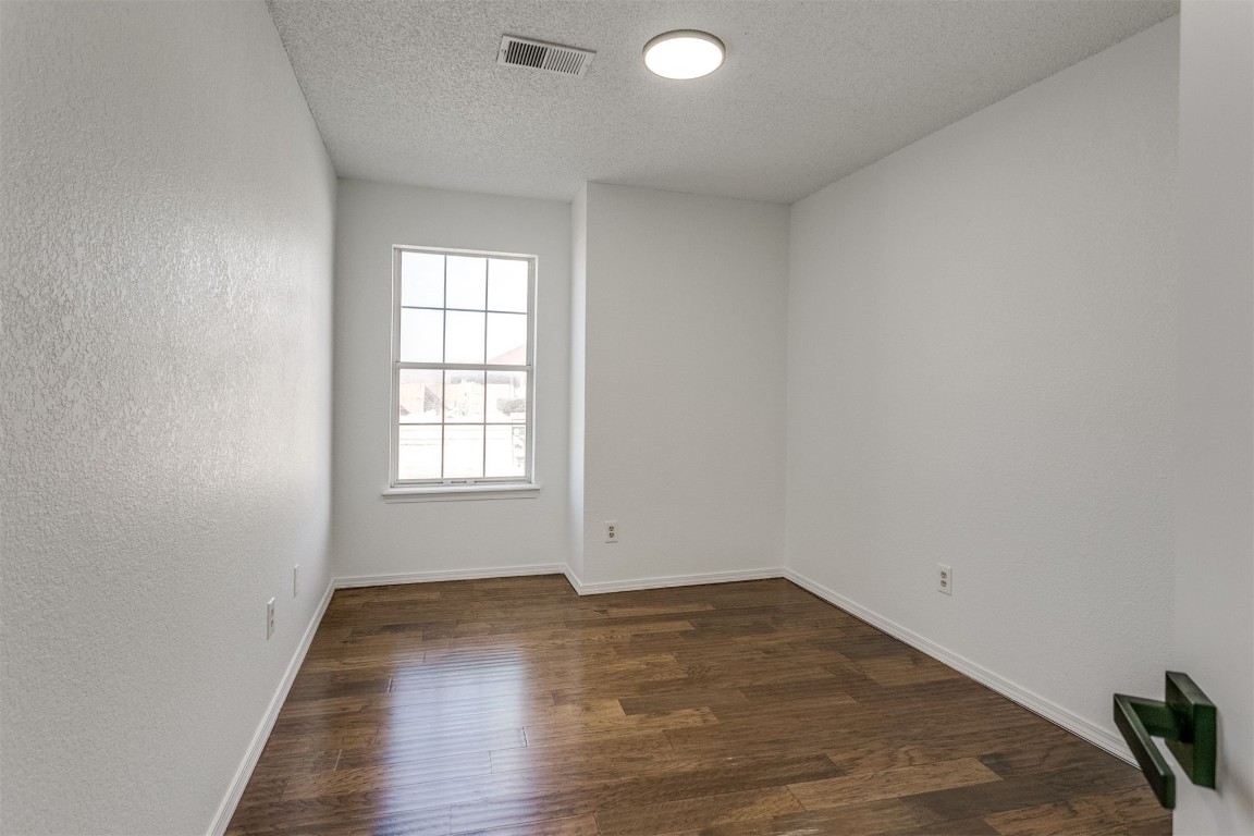 15124 Todd Way, Oklahoma City, OK 73170 spare room with dark hardwood / wood-style flooring and a textured ceiling