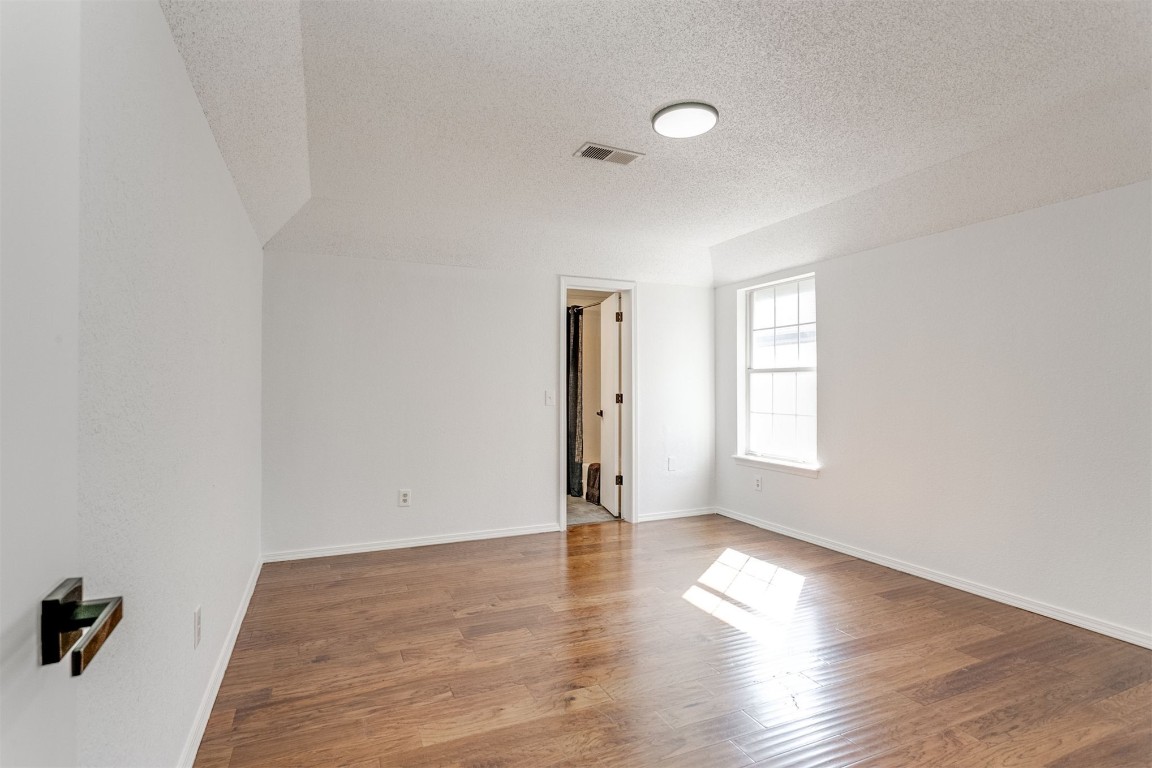 15124 Todd Way, Oklahoma City, OK 73170 unfurnished room with hardwood / wood-style floors and a textured ceiling