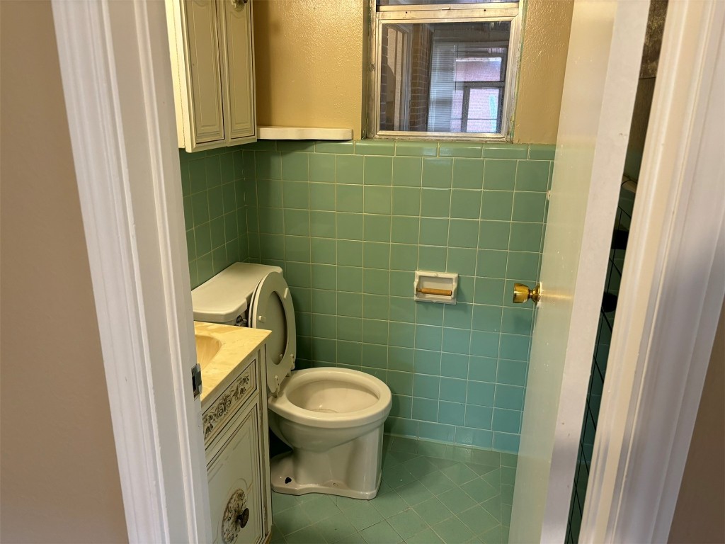 1125 NW 88th Street, Oklahoma City, OK 73114 bathroom featuring vanity, tile floors, toilet, and tile walls