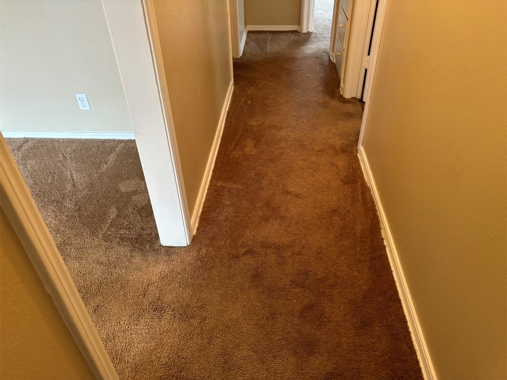1125 NW 88th Street, Oklahoma City, OK 73114 hallway with dark colored carpet