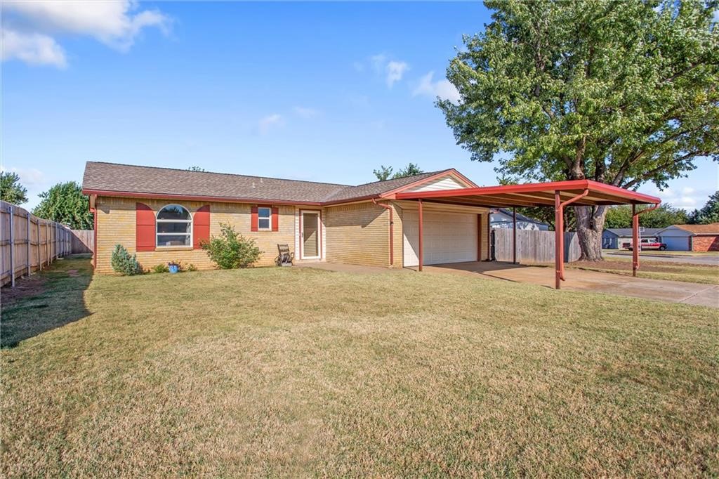 814 Cherrywood Lane, Yukon, OK 73099 ranch-style house with a front yard and a garage