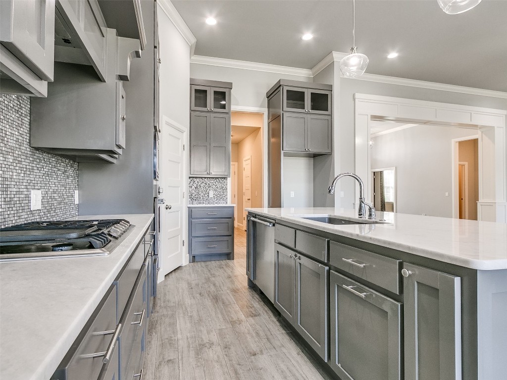 4325 SW 129th Street, Oklahoma City, OK 73173 kitchen featuring pendant lighting, backsplash, light wood-type flooring, and gray cabinetry