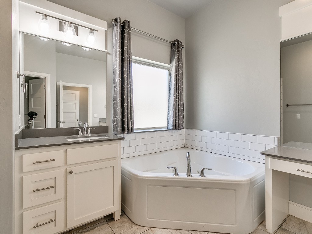 4325 SW 129th Street, Oklahoma City, OK 73173 bathroom with tile floors, vanity, and a tub
