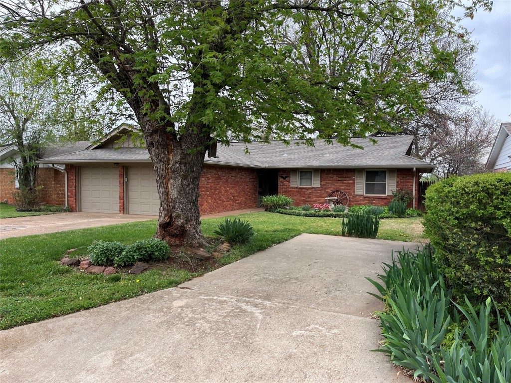 2004 Michael Drive, Edmond, OK 73013 ranch-style home with a front lawn and a garage