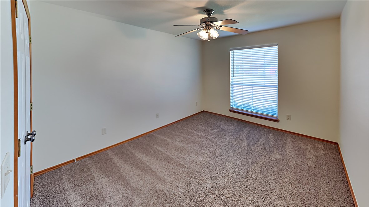 1400 SW 23rd Street, Moore, OK 73170 empty room with ceiling fan and dark carpet