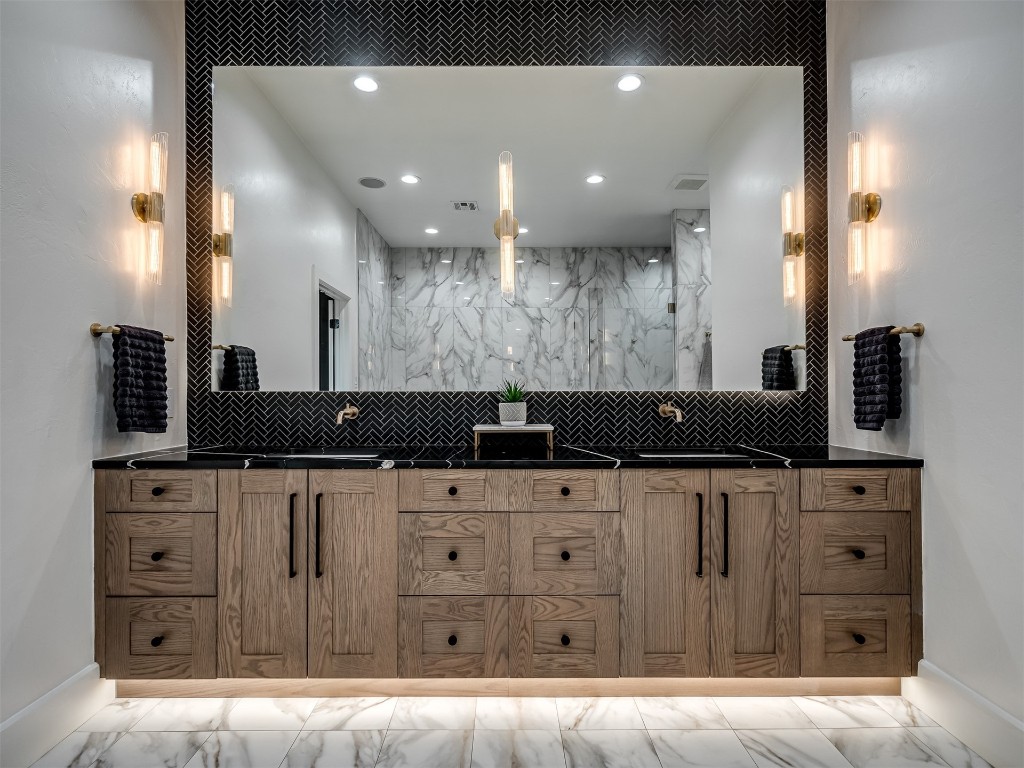 1348 N Post Road, Edmond, OK 73007 bathroom featuring dual bowl vanity, tile flooring, and tasteful backsplash