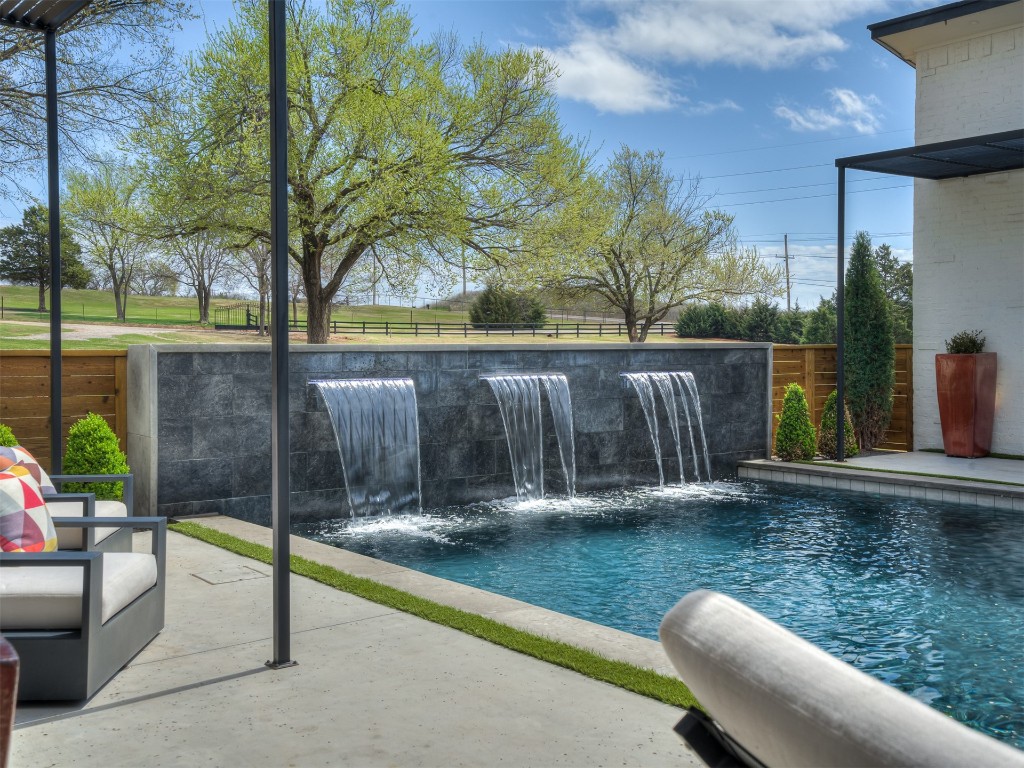 1348 N Post Road, Edmond, OK 73007 view of pool featuring pool water feature and a patio