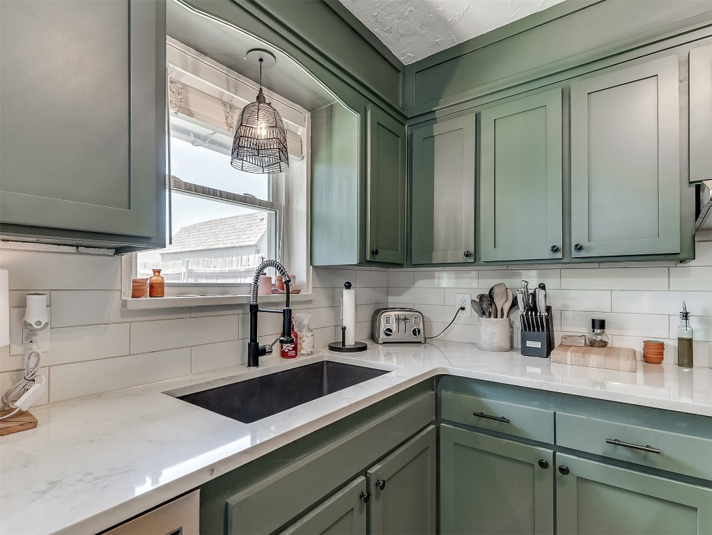 114 E Cypress Avenue, Yukon, OK 73099 kitchen featuring sink, green cabinets, tasteful backsplash, and light stone countertops