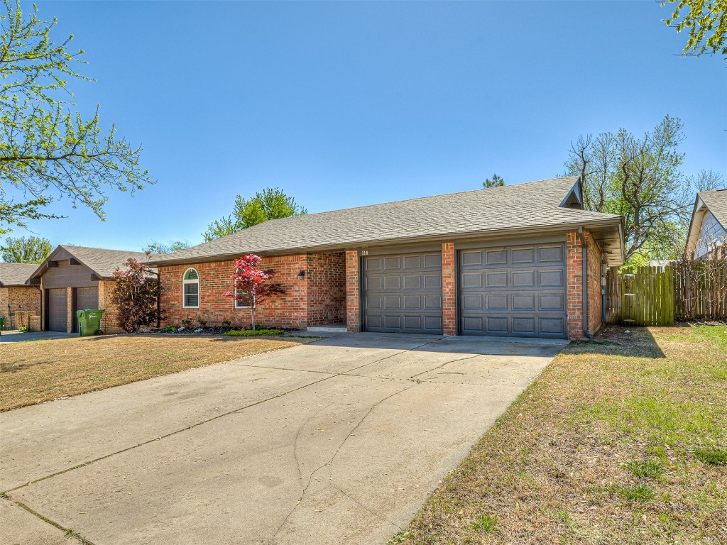 114 E Cypress Avenue, Yukon, OK 73099 ranch-style home with a front lawn and a garage