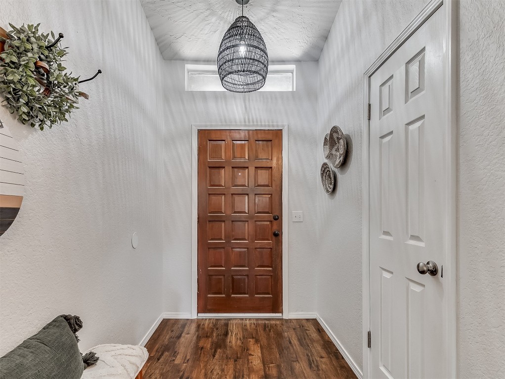 114 E Cypress Avenue, Yukon, OK 73099 entrance foyer with an inviting chandelier and dark wood-type flooring